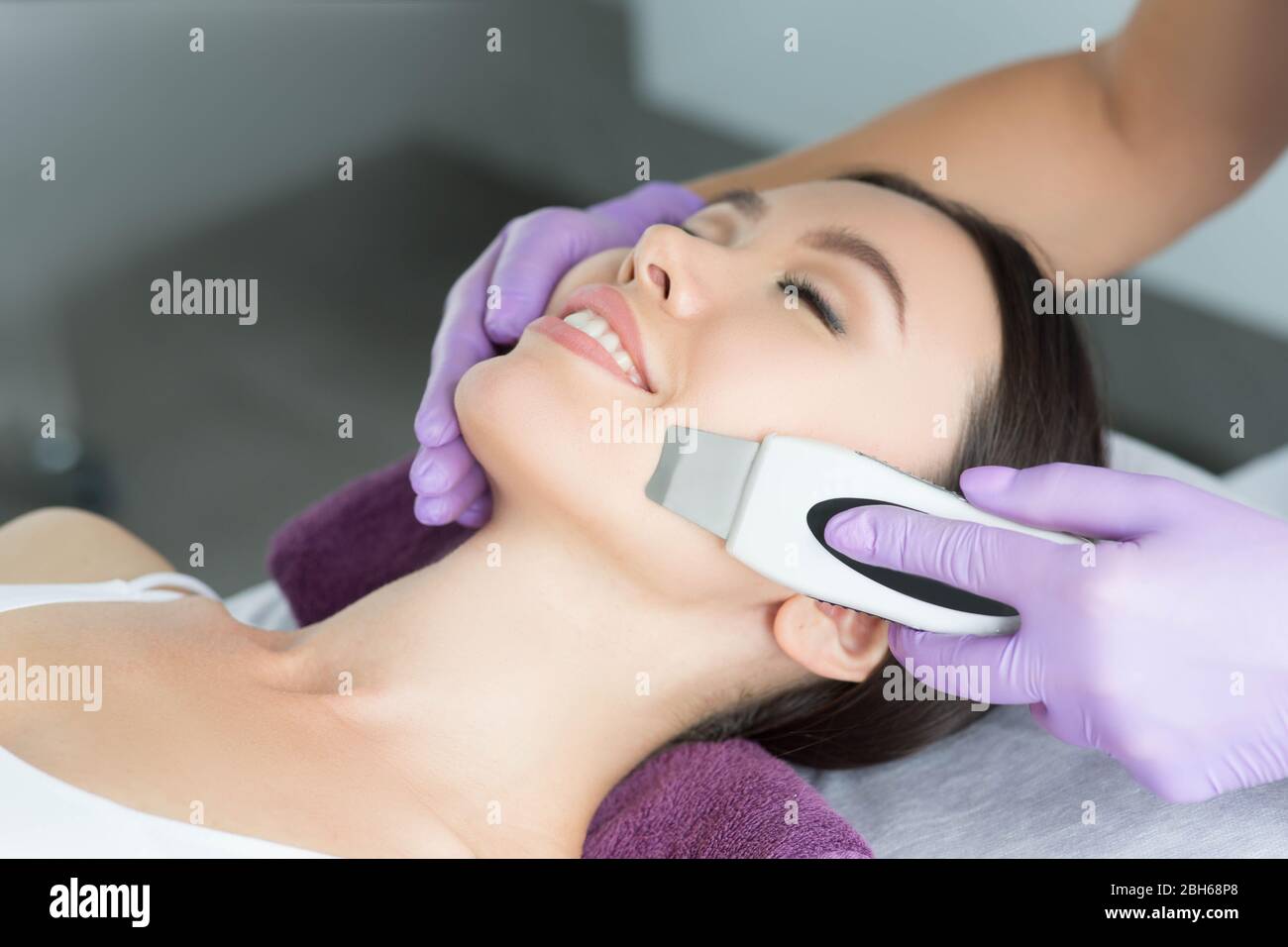 woman receiving ultrasound cavitation facial peel. get clean face without blackheads and skin defects using ultrasound equipment Stock Photo