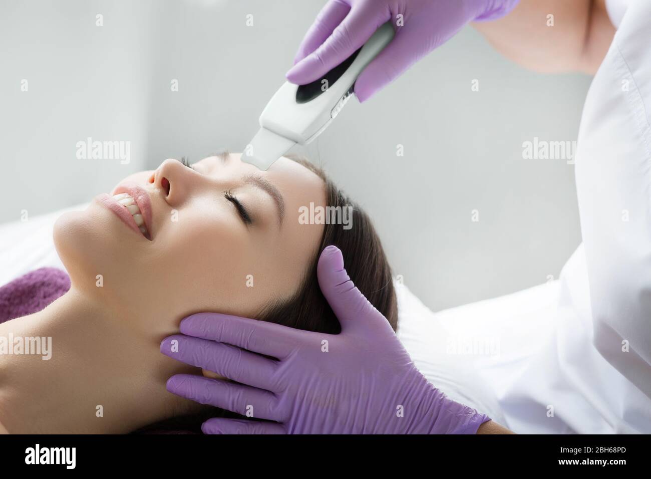 woman receiving ultrasound cavitation facial peel. get clean face without blackheads and skin defects using ultrasound equipment Stock Photo
