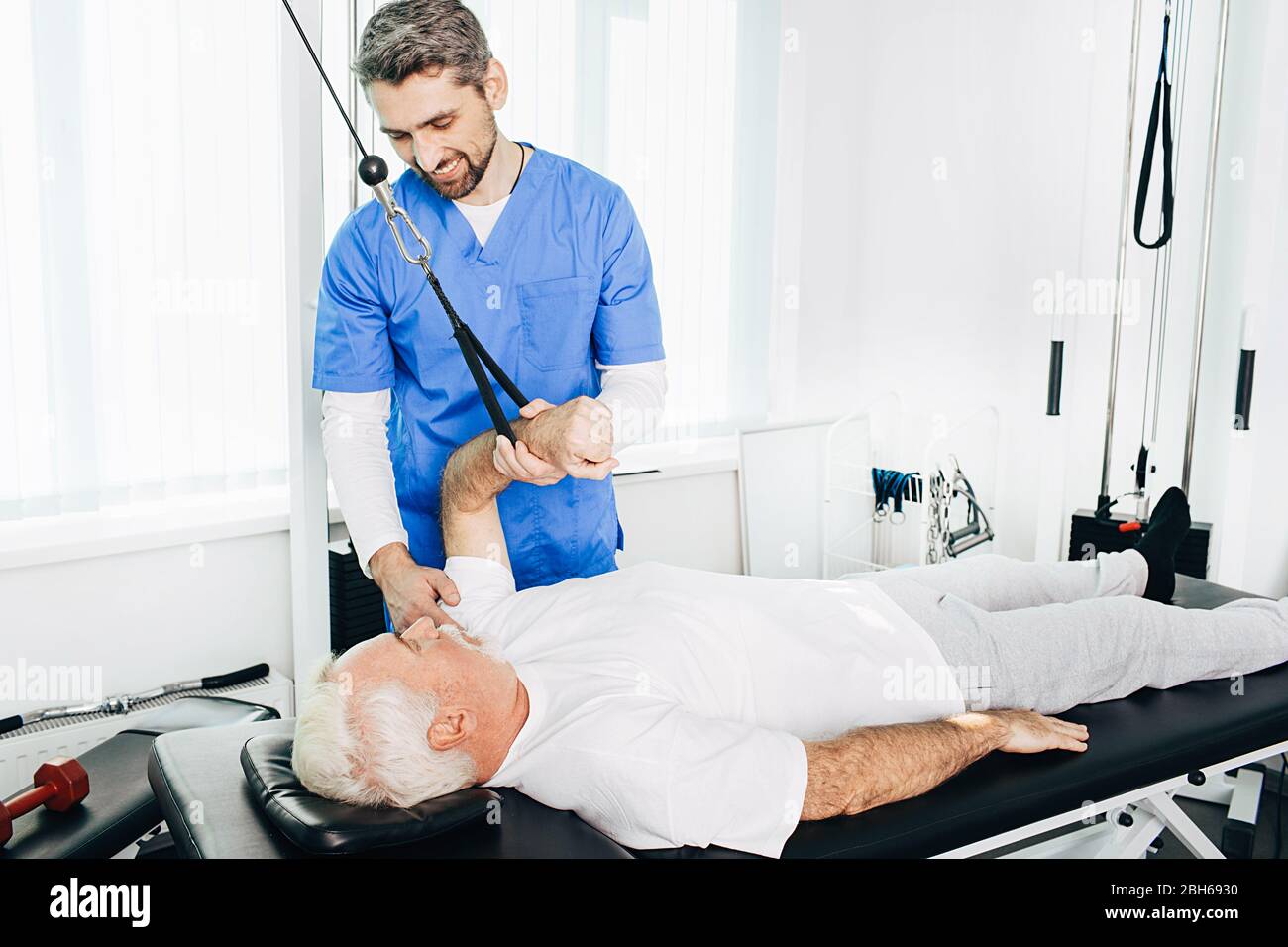 kinesiologist doing special exercise with his aged patient. Alternative