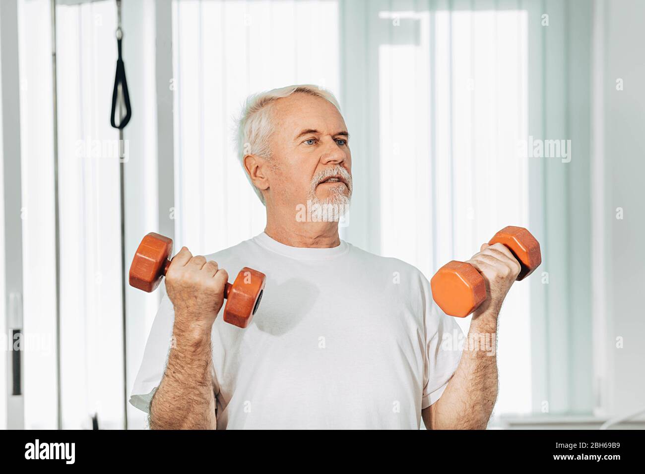 Senior man lifting weights at an exercise class. healthy lifestyle old people Stock Photo