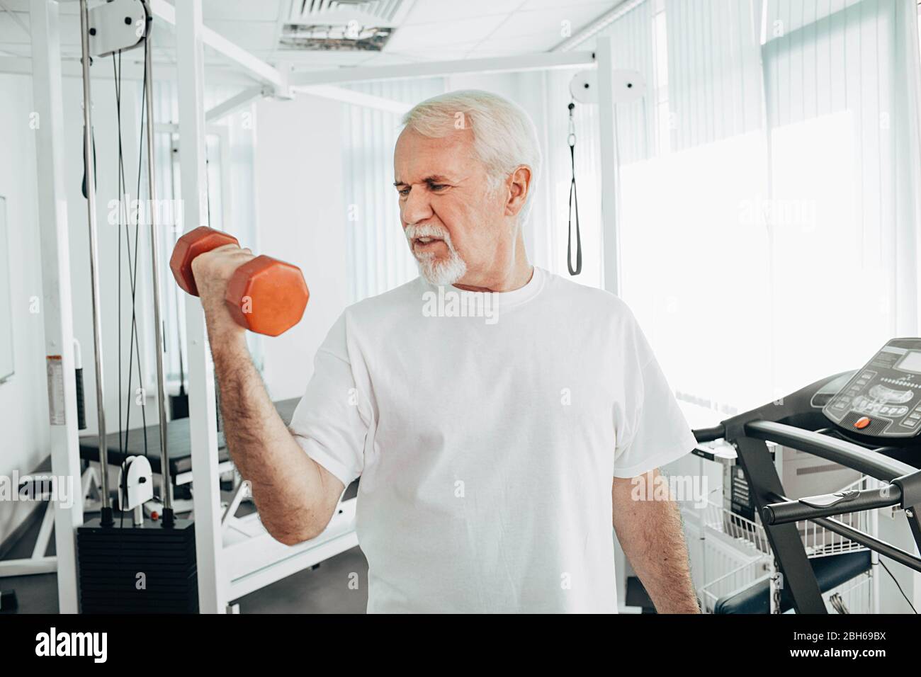Senior man lifting weights at an exercise class. healthy lifestyle old people Stock Photo
