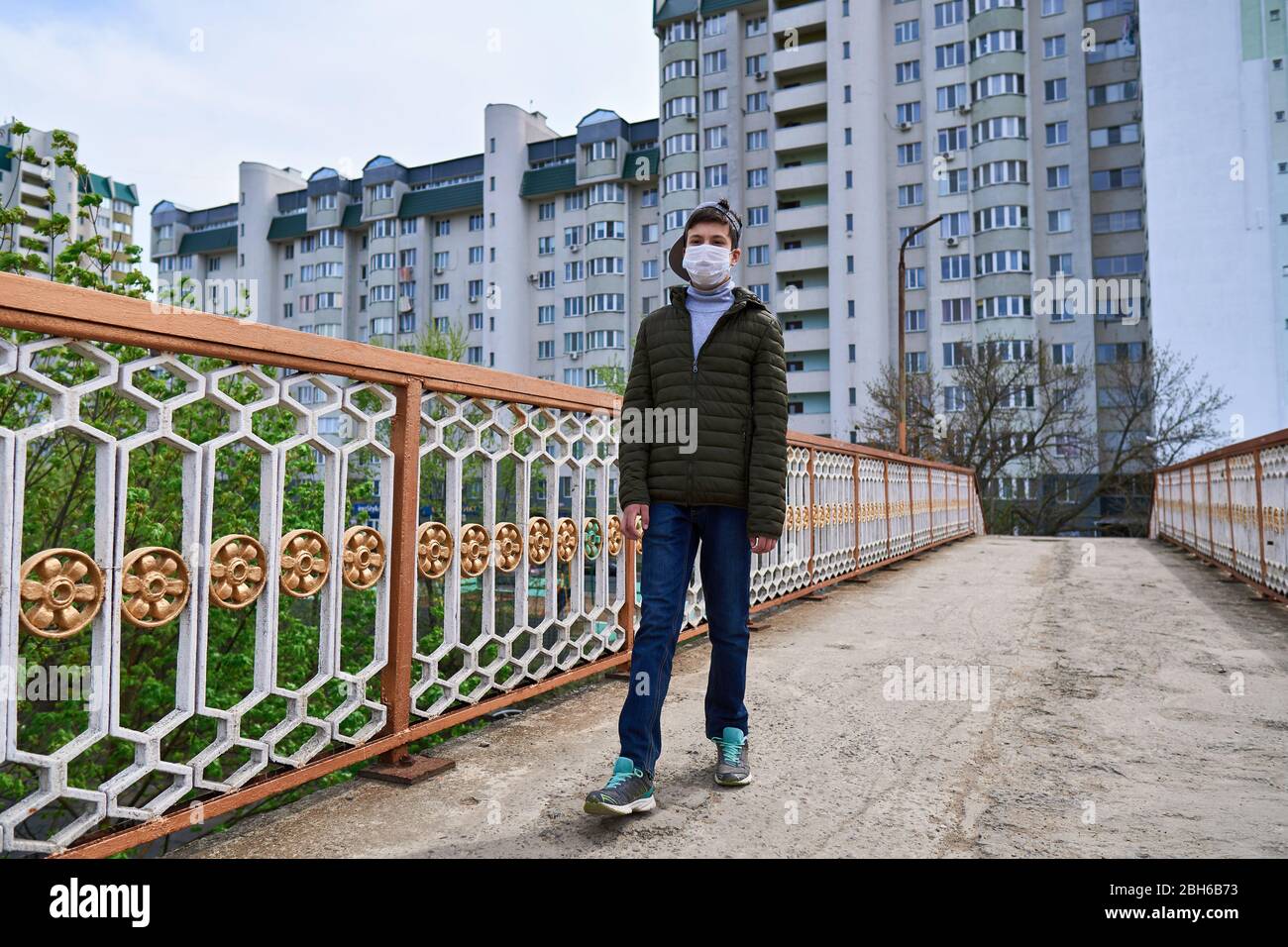 Picture of teen boy walks down the street during the day, a pedestrian walkway and ...