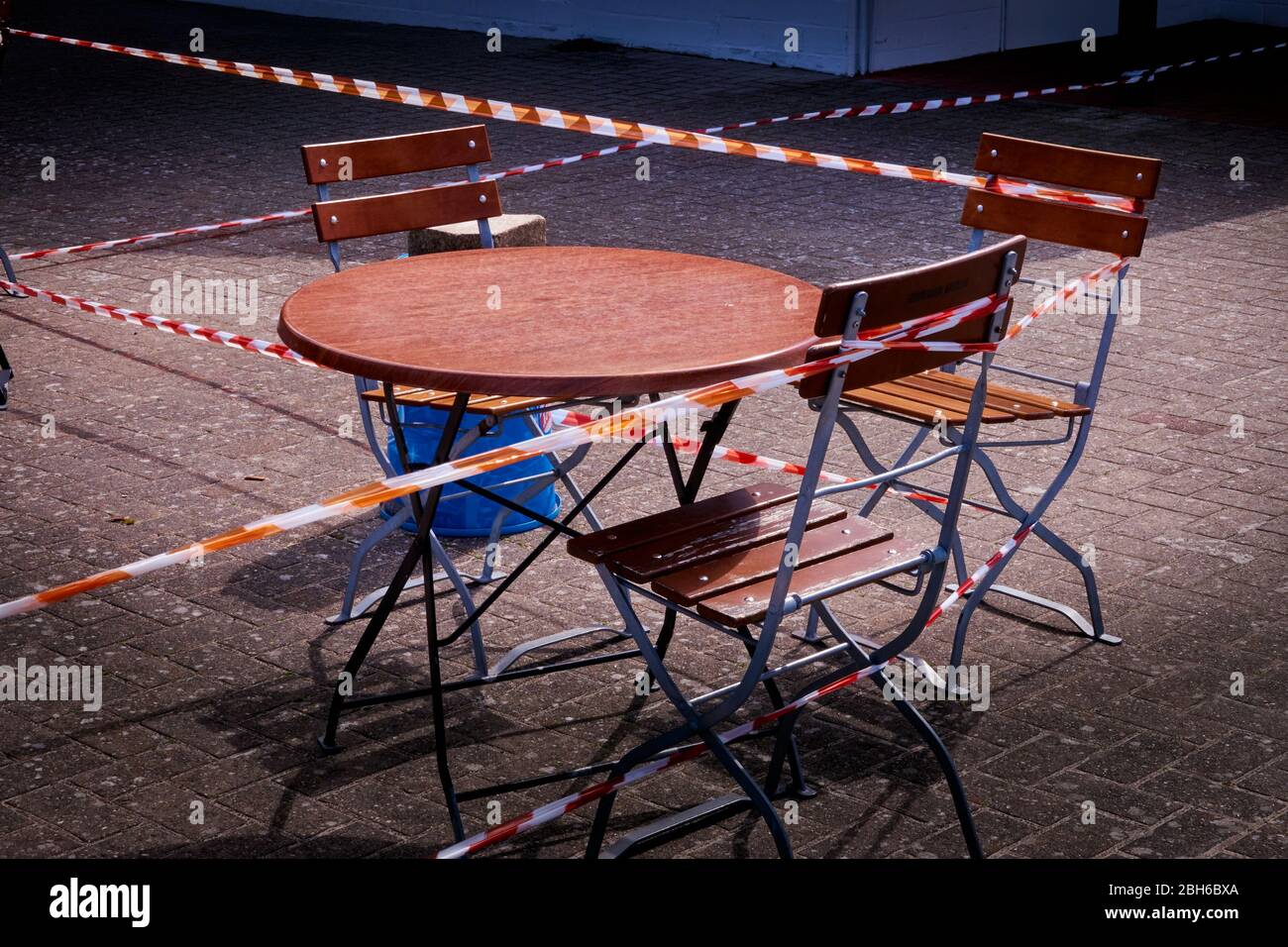 Tables and chairs in an outdoor restaurant locked due to the Corona crisis Stock Photo