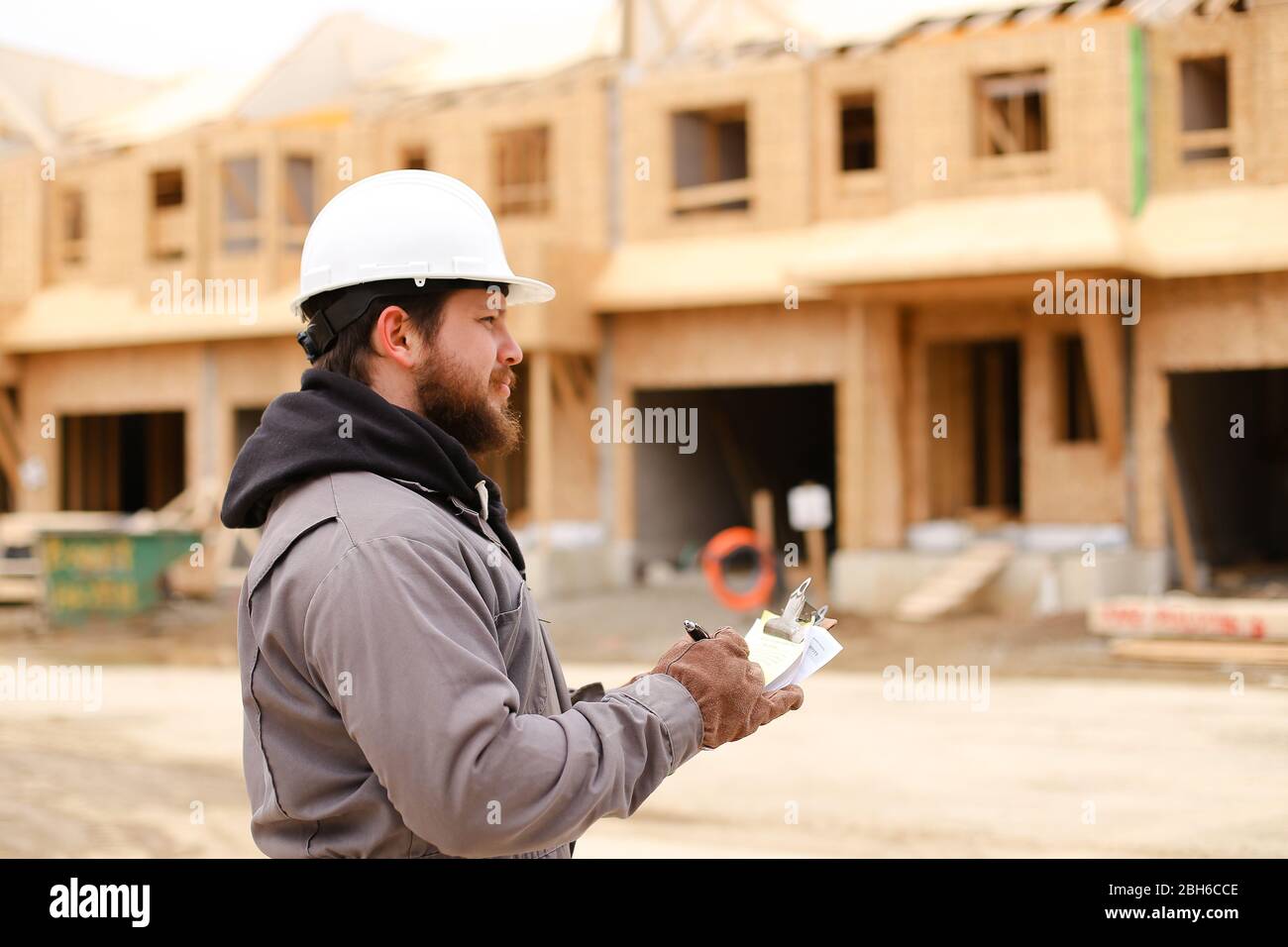 European builder drawing plan in notebook at construction site. Stock Photo