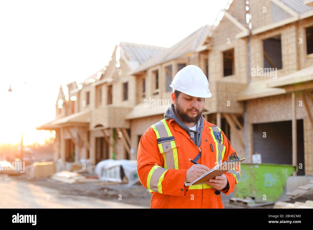 Architect writing in notebook on construction site. Stock Photo