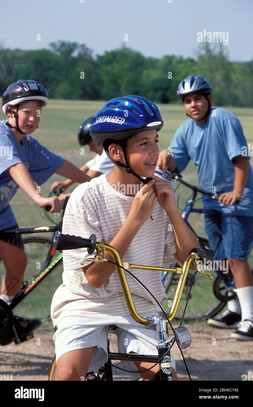 Austin Texas USA 13 year old boy puts on safety helmet correctly before mountain biking with his friends at Zilker Park. Bob Daemmrich Stock Photo Alamy