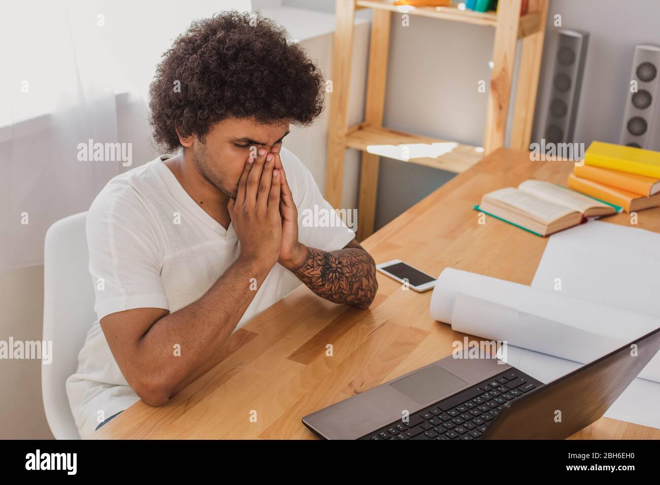 Curly haired stylish man sick and tired after work , sitting at his ...