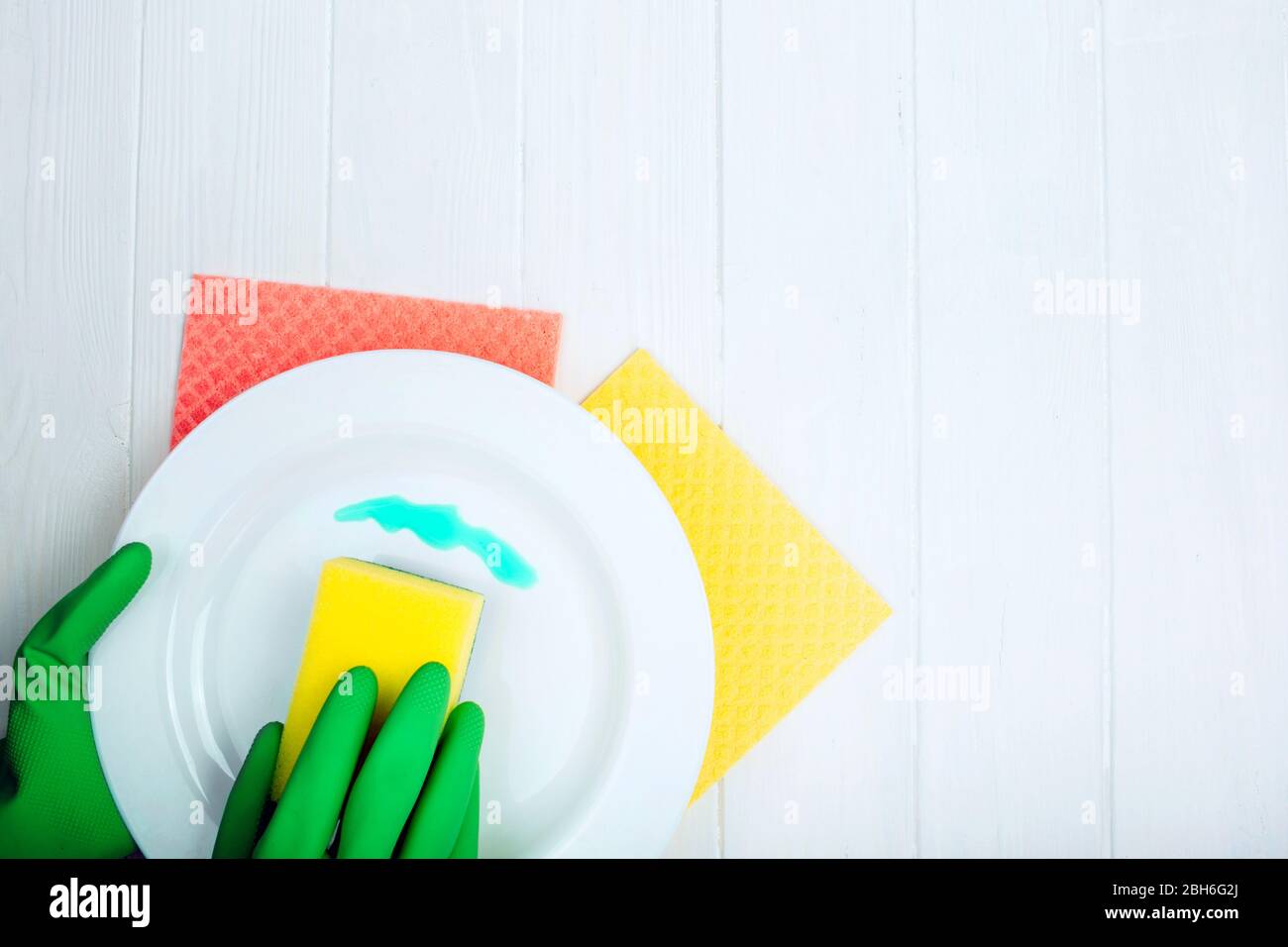 hands in rubber gloves washing dishes, top view with copy space Stock Photo