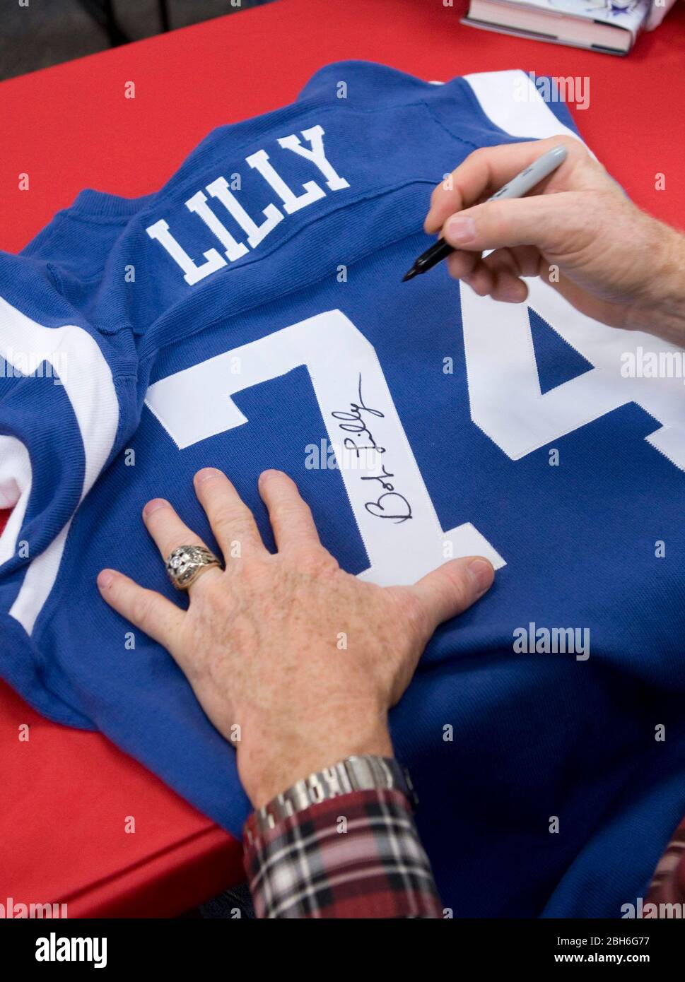 Austin, Texas USA, November 21, 2008: Legendary Dallas Cowboy defensive tackle Bob Lilly uses a Sharpie pen to autograph a replica of his jersey at a book signing for his new book, 'A Cowboy's Life.' Lilly's 14-year NFL career from 1961 to 1974 was highlighted by seven All-Pro selections and one Super Bowl victory in 1972.  ©Bob Daemmrich Stock Photo