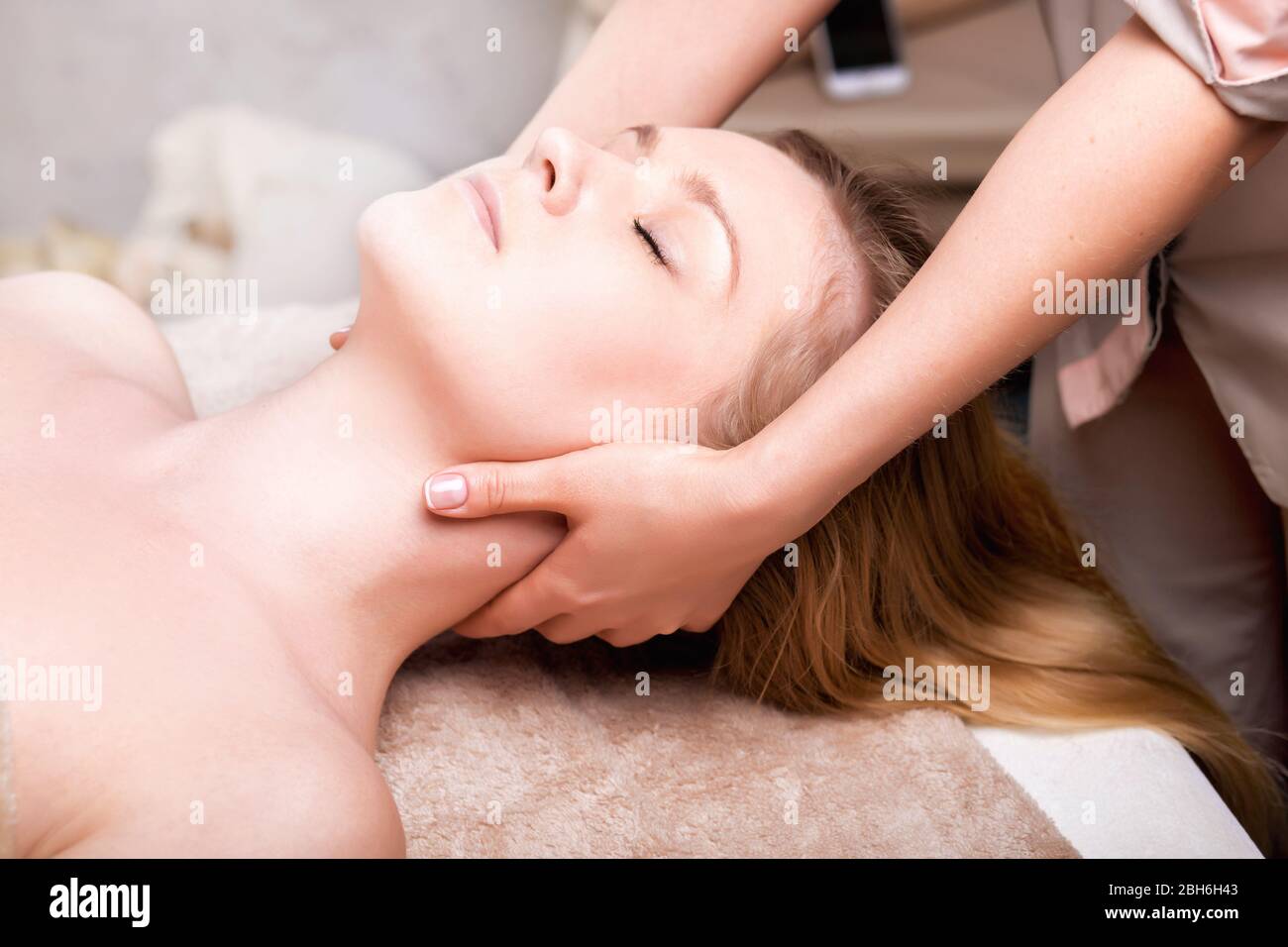 Blonde woman having facial massage in spa salon. close-up Stock Photo
