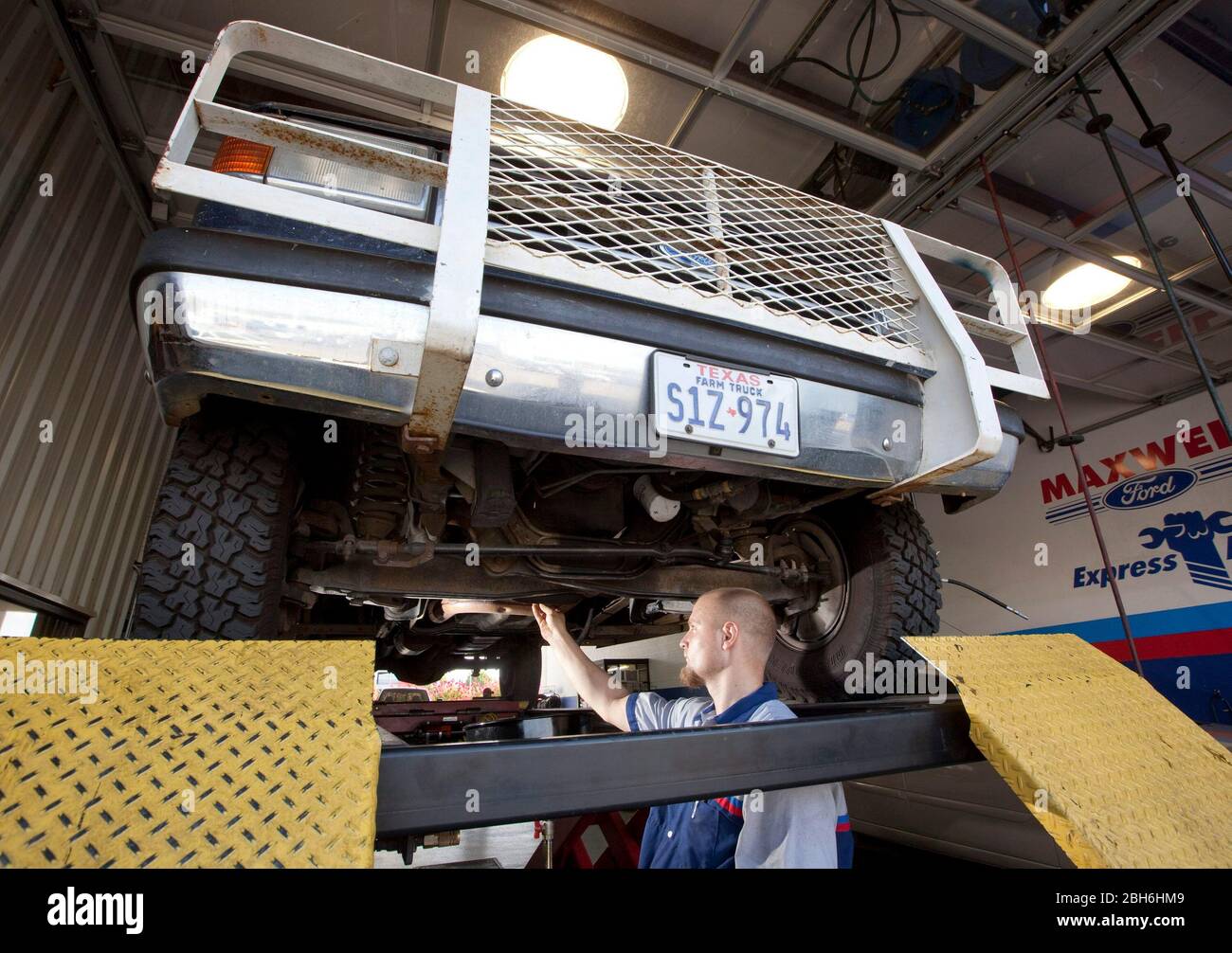 Austin, Texas USA, August 10, 2009: Mechanic Taylor Ferguson drains the oil from the V-8 engine in an older F250 Ford truck prior to seizing the engine on the trade-in at Maxwell Ford dealership. The 'Cash for Clunkers' program was re-authorized by Congress last week.    ©Bob Daemmrich Stock Photo