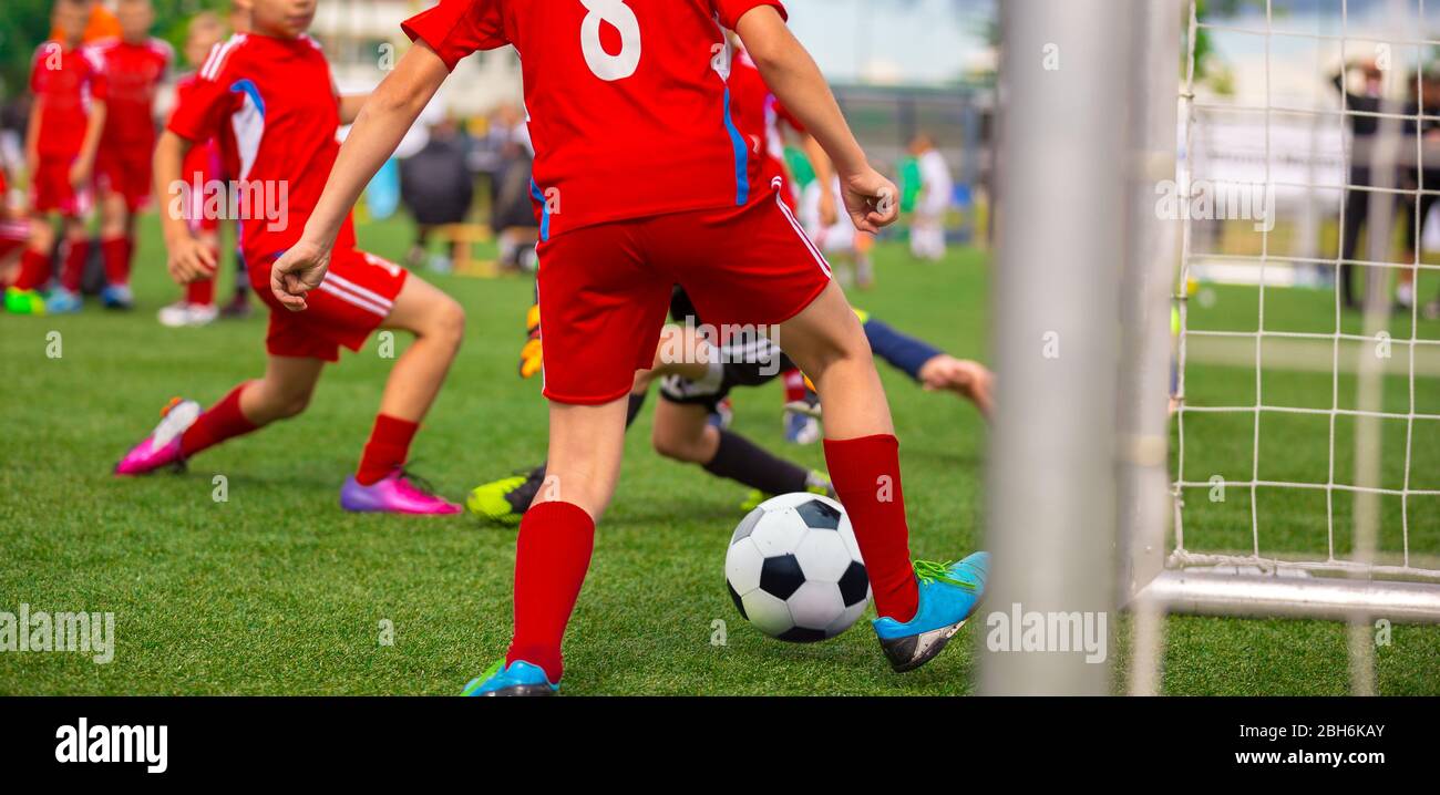 Young Boy Soccer Player Scoring Goal in Match. Junior Level School