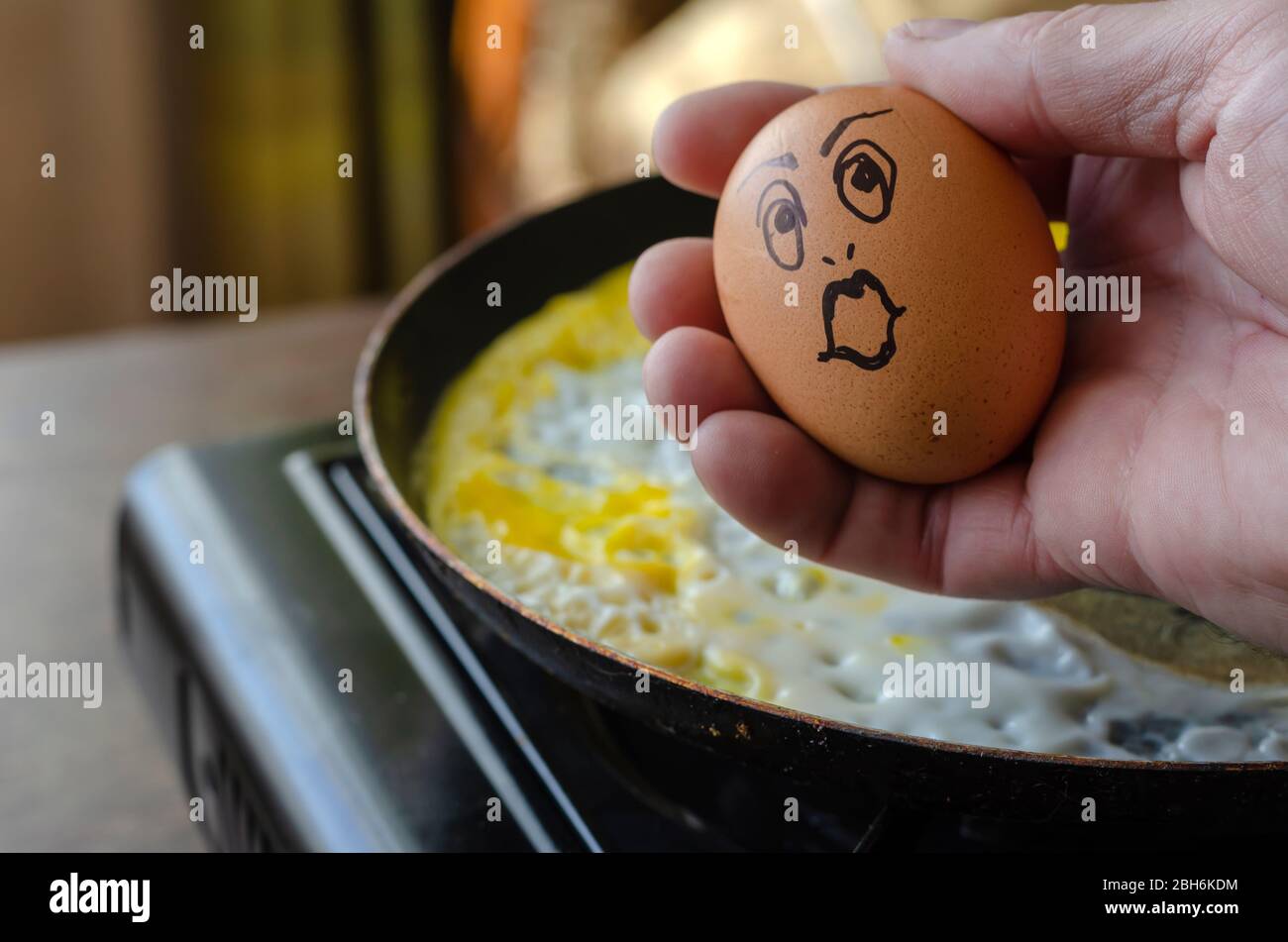 Surprised chicken egg in the hand. Raw chicken egg with a grimace of