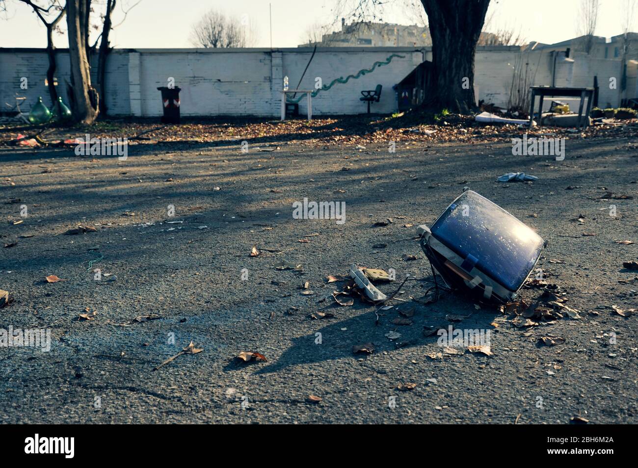 Old CRT (Cathode ray tube) television on a asphalt floor in an abandoned area. Environmental degradation concept. Obsolete technologies concept. Post Stock Photo