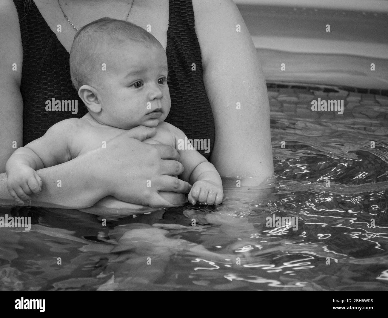Small baby learning to swim with mother Stock Photo
