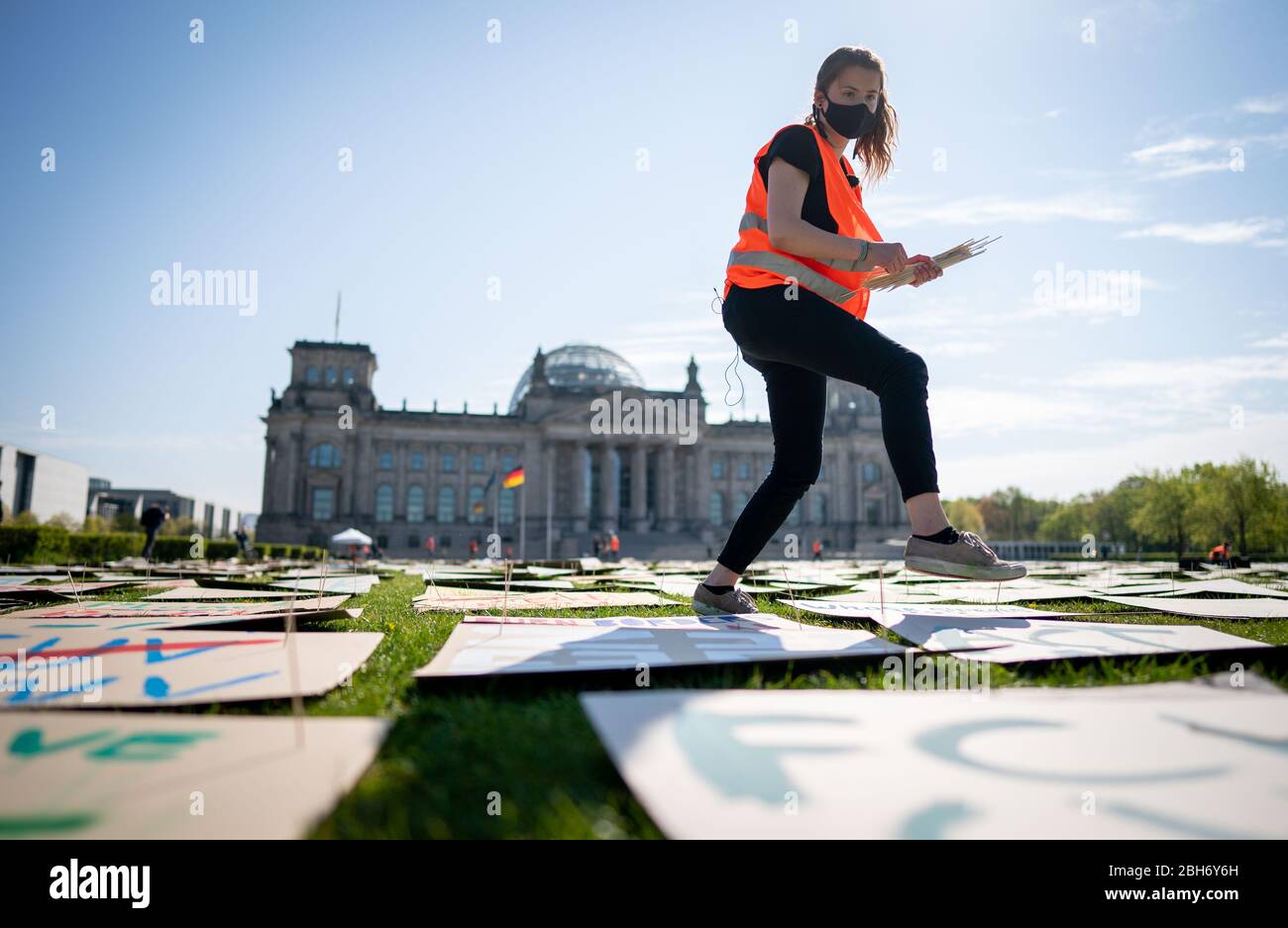 Berlin, Germany. 24th Apr, 2020. Luisa Neubauer of Fridays for Future lays out protest posters for the alternative climate strike on the Reichstag meadow. Because of the continuing spread of the corona virus, the climate strike is being digitally distributed on the Internet and strikers can participate via the website at www.fridaysforfuture.de/netzstreikfursklima. Credit: Kay Nietfeld/dpa/Alamy Live News Stock Photo