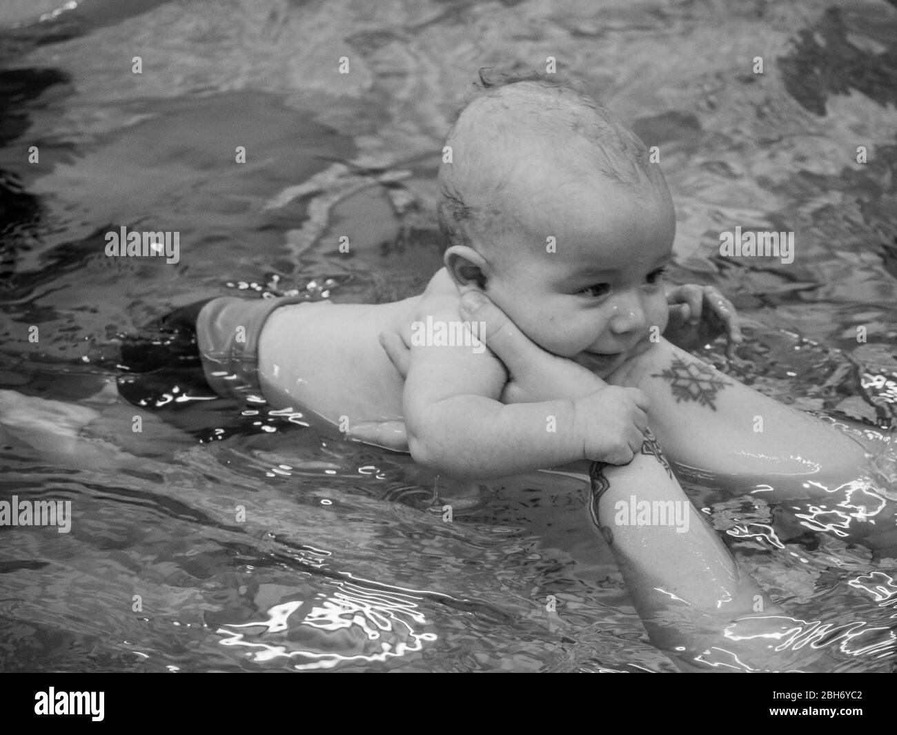 Small baby learning to swim with mother Stock Photo