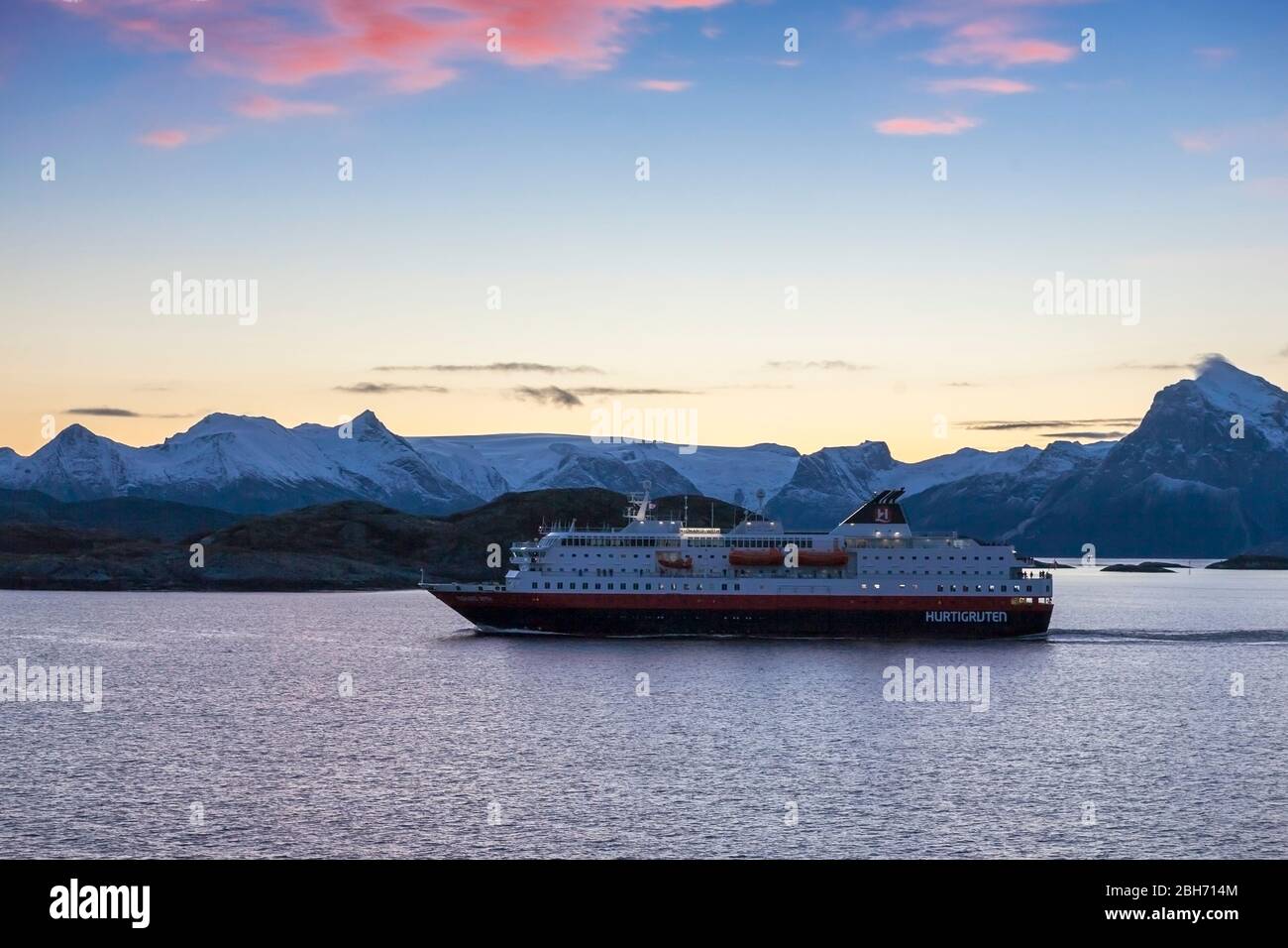 Hurtigruten ship 'Richard With' crosses the entrance to Tjongsfjorden, Rødøy Municipality, Nordland, Norway at dawn Stock Photo