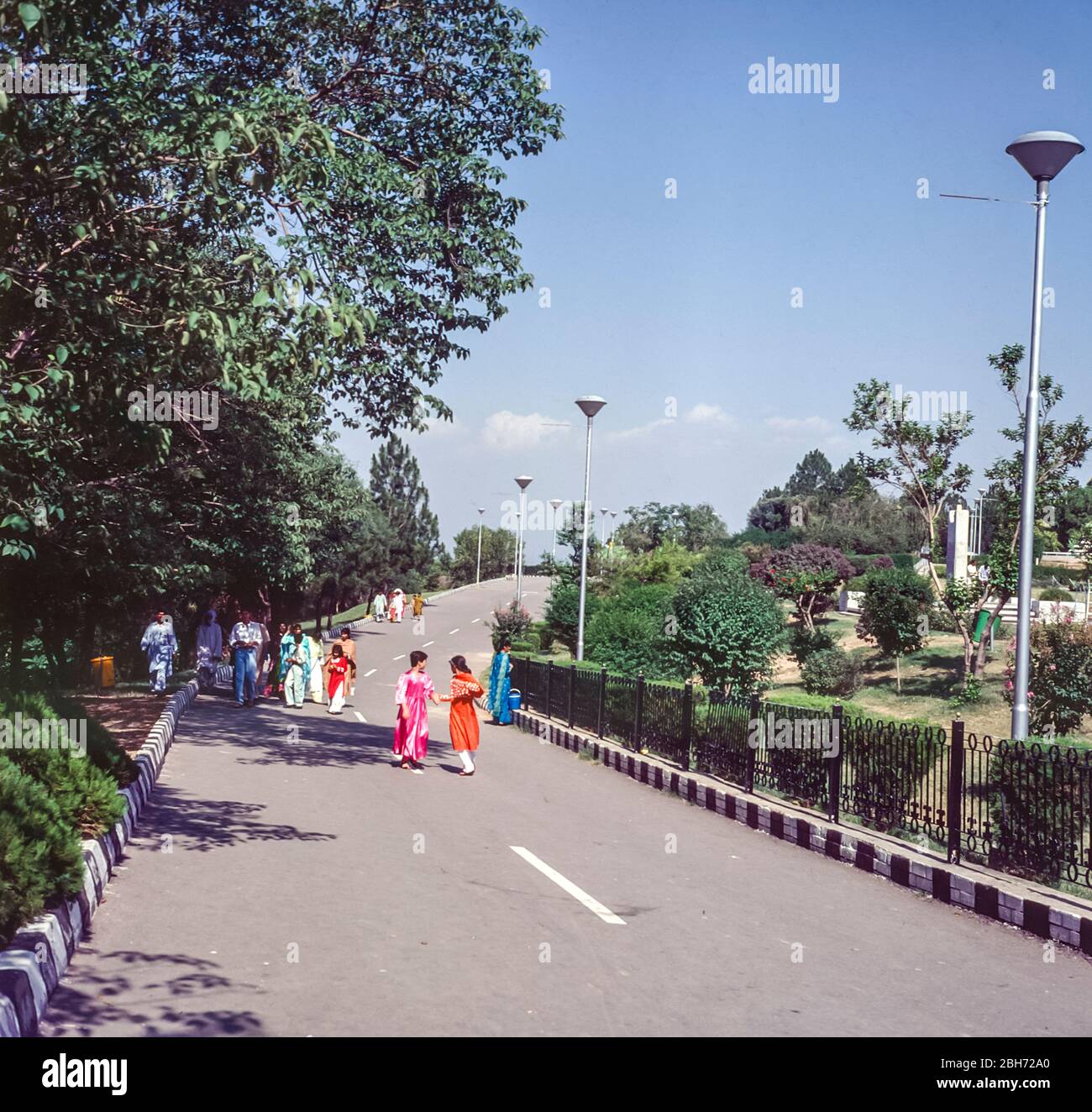 Pakistan, Islamabad street scene with young girls dressed in brightly coloured dresses making their way to the Shakaparian Park and gardens Stock Photo