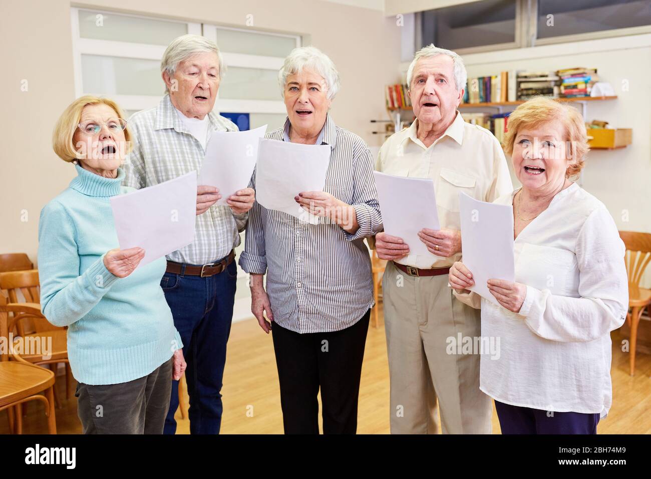 Seniors from the senior choir sing together at the choir rehearsal in the retirement home Stock Photo
