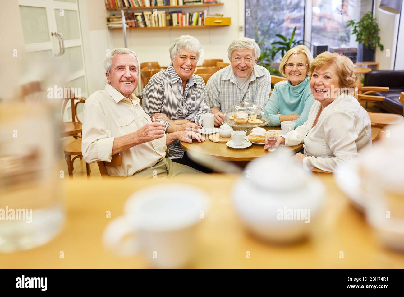 Seniors as pensioners and friends drink coffee together in the