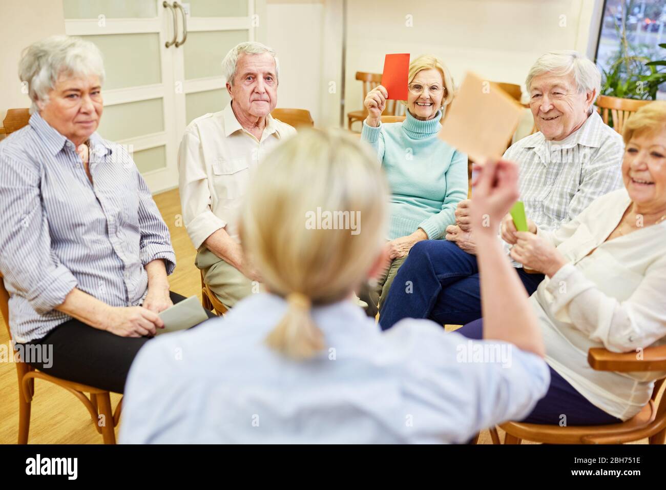 Group of seniors and therapists do memory training with colorful pieces