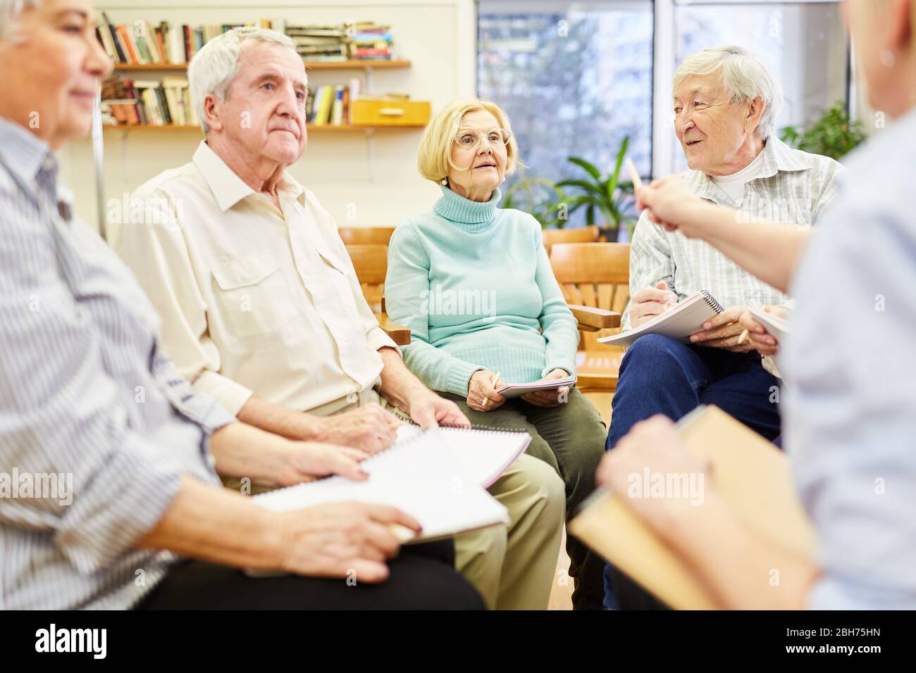 Senior group and therapist in group psychotherapy in a retirement home Stock Photo