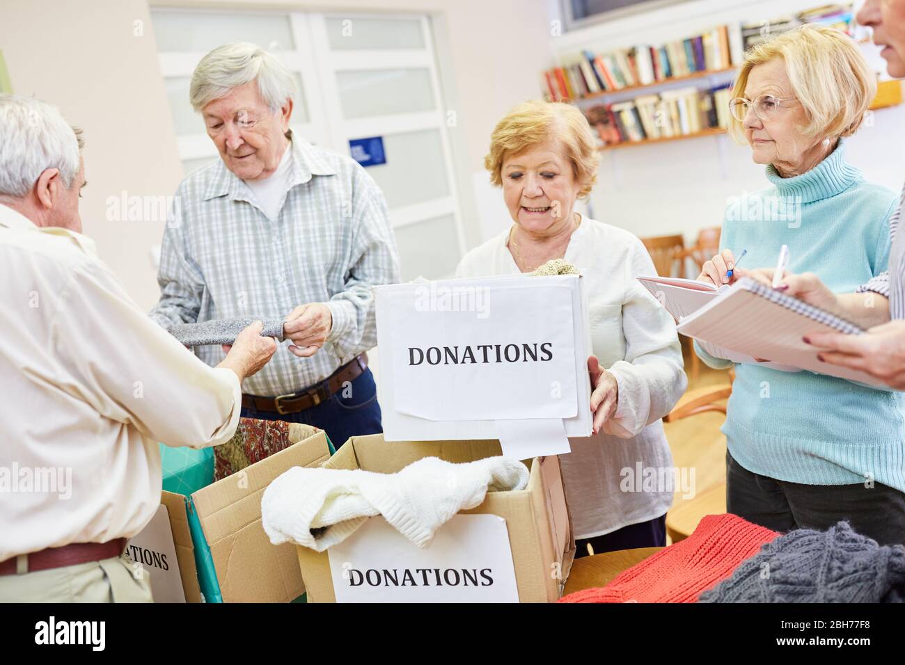 Seniors as voluntary helpers collect clothing donation for the needy in