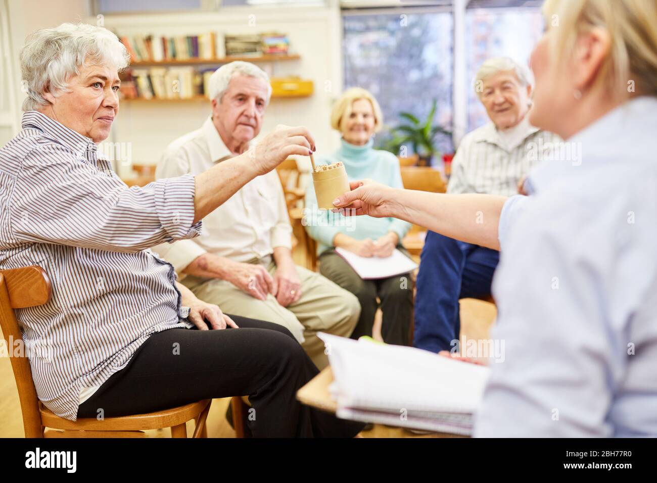 Psychotherapist and seniors play a game in occupational therapy Stock