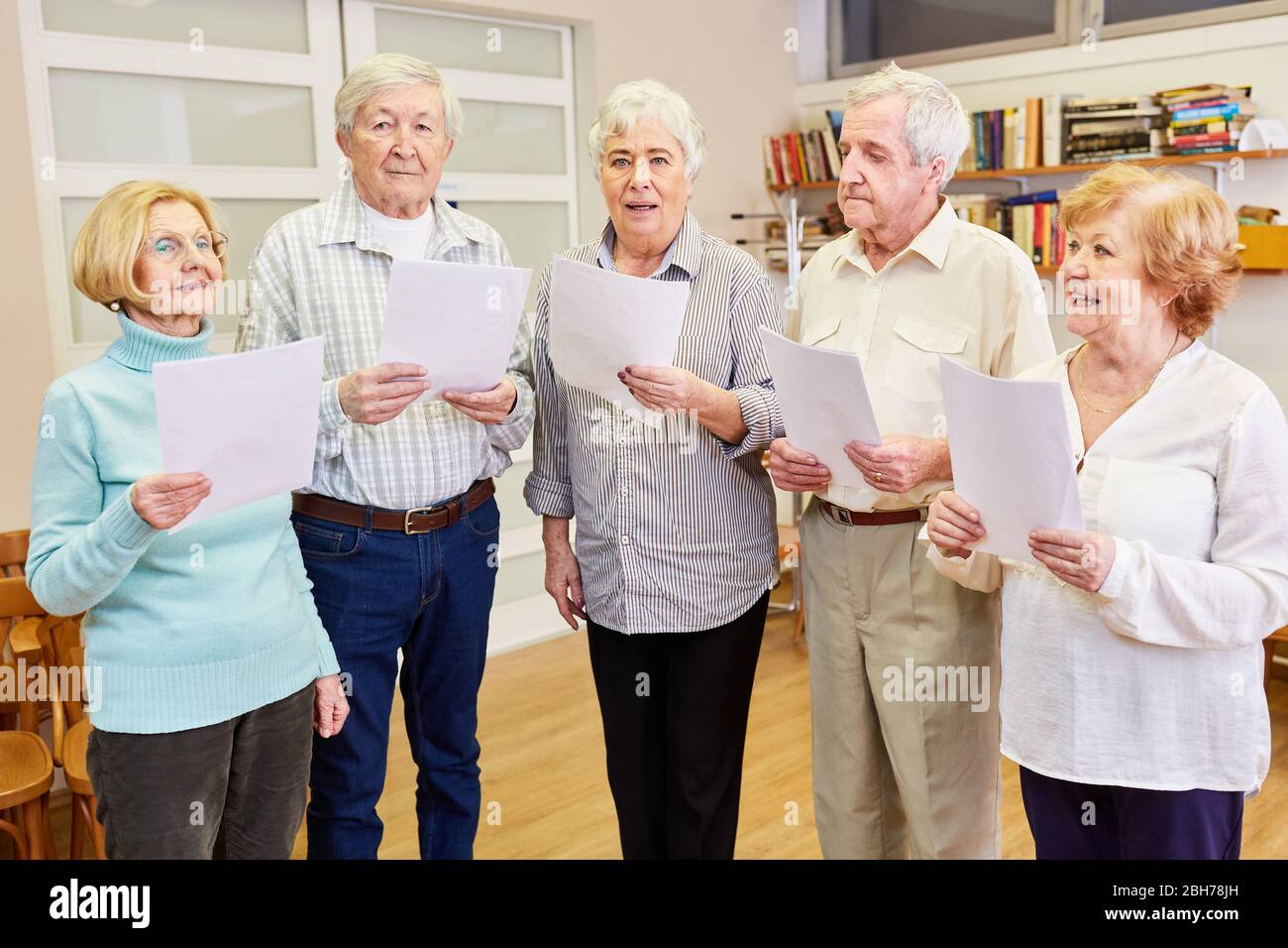 Group of seniors with dementia singing together in a choir rehearsal Stock Photo