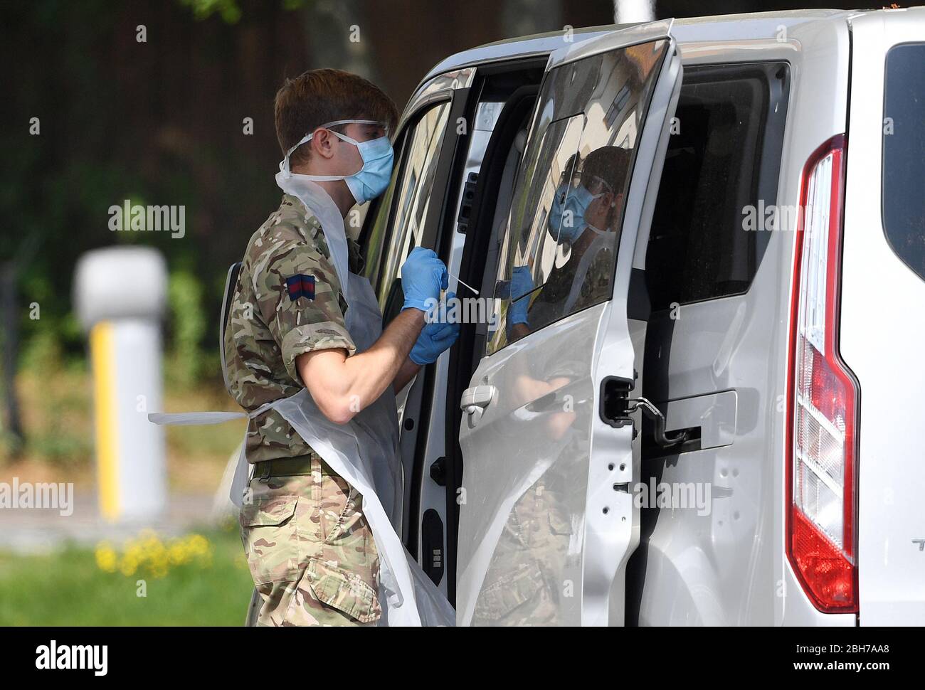 A soldier takes a swab from a key worker at a drive-through testing station at Chessington World of Adventures in Surrey, as the UK continues in lockdown to help curb the spread of the coronavirus. Stock Photo
