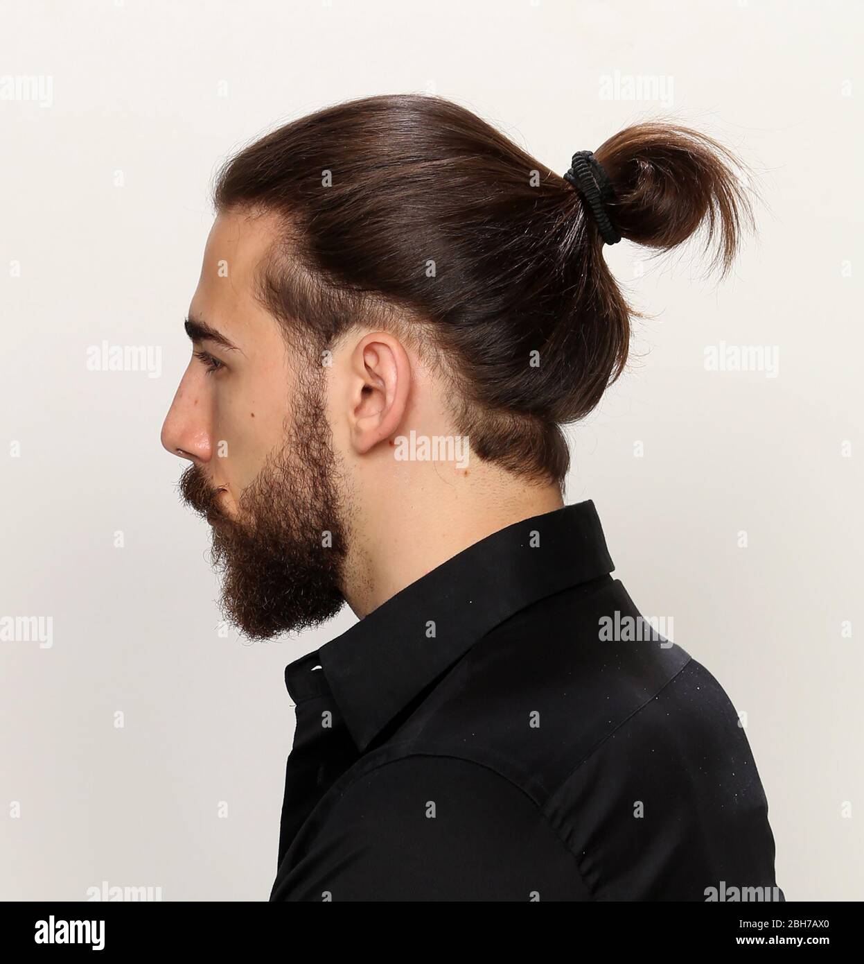 Young, fashionable male model with long hair and beard posing in studio on  isolated background. Fashion, business, modeling concept Stock Photo - Alamy