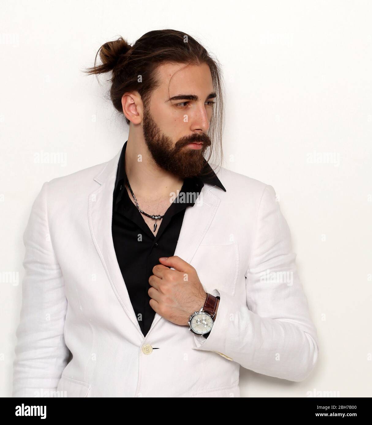Young, fashionable male model with long hair and beard posing in studio on  isolated background. Fashion, business, modeling concept Stock Photo - Alamy