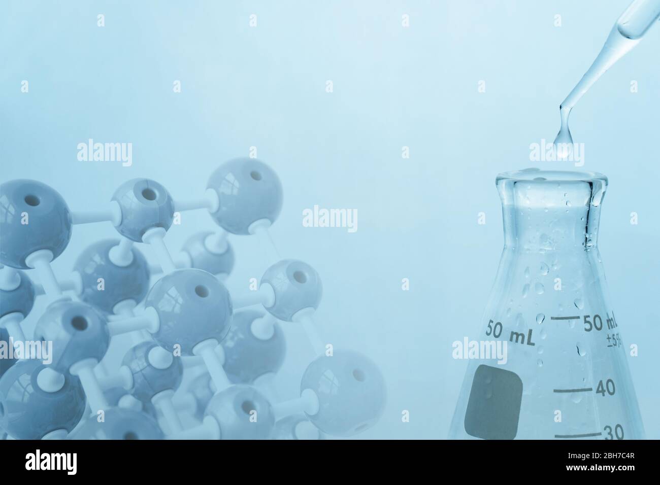 glass flask with water drop in blue medical sciene laboratory with molecular chemistry model background Stock Photo