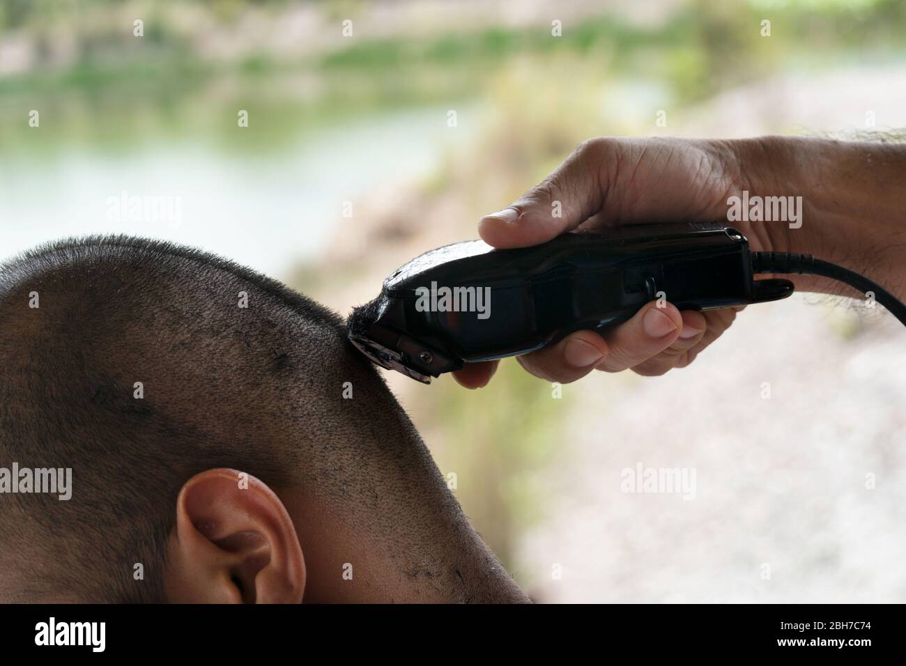 close up man hand with clipper for hair cutting at home during disease quarantine period Stock Photo