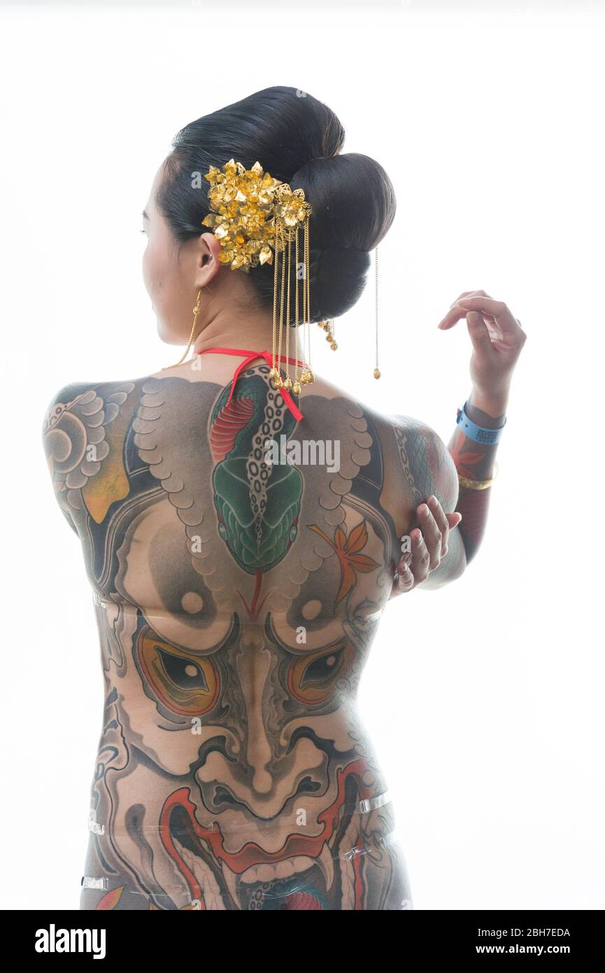 An asian woman with a full body body tattoo, in a japanese style at the 12th London Tattoo Convention 2016, Tobacco Dock, 50 Porters Walk, London, UK. Stock Photo
