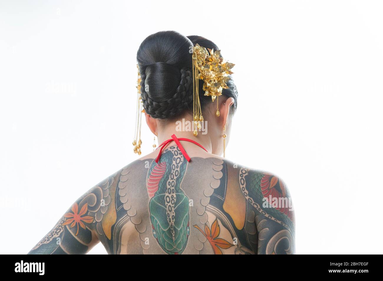 An asian woman with a full body body tattoo, in a japanese style at the