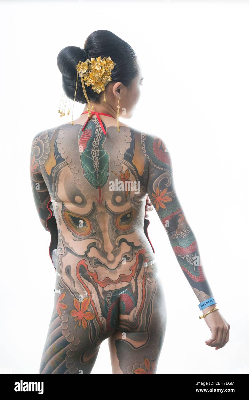 An asian woman with a full body body tattoo, in a japanese style at the 12th London Tattoo Convention 2016, Tobacco Dock, 50 Porters Walk, London, UK. Stock Photo