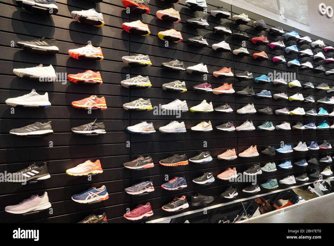 Shop display of a lot of Sports shoes on a wall. A view of a wall