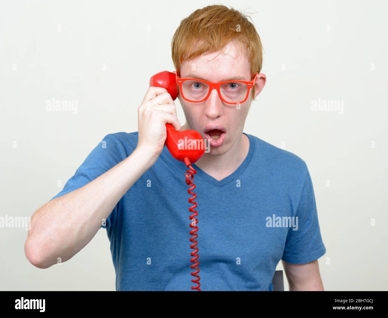 Man Using Red Telephone Man with red hair talking on old telephone and looking shocked Stock ...