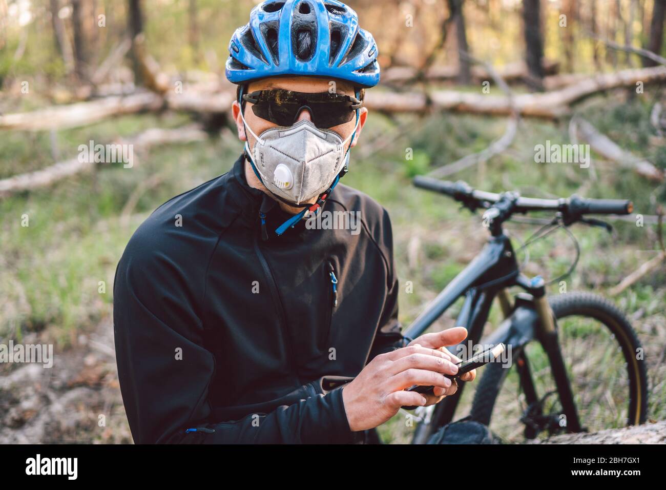 Cyclist wearing pollution mask. Young guy in respirator with filter pm