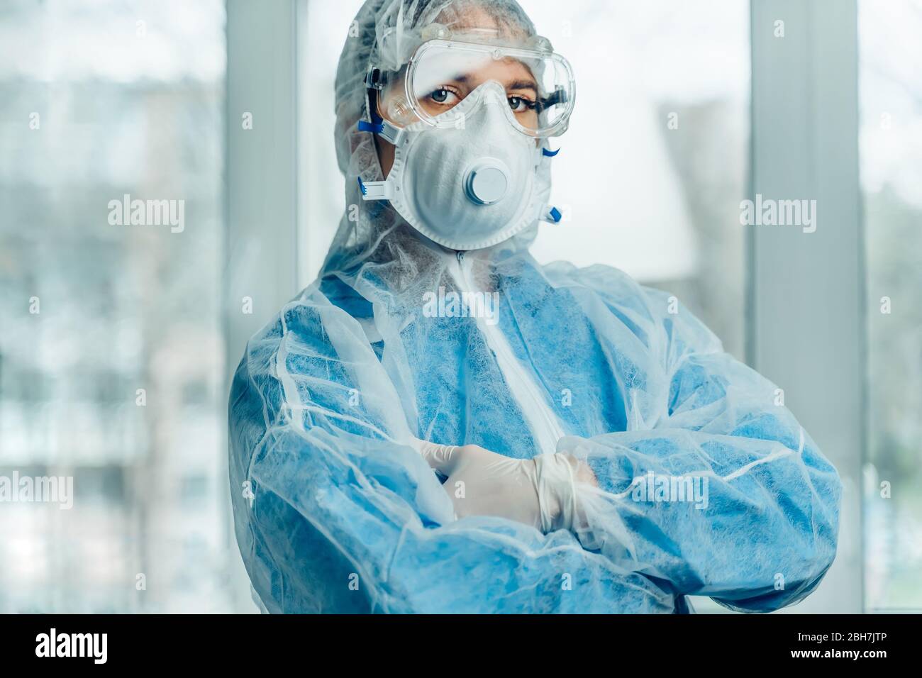 Portrait of woman doctor weaing protective suit during coronavirus pandemic, . Hazard suit, respiratory mask, gloves and glasses clinic or hospital Stock Photo