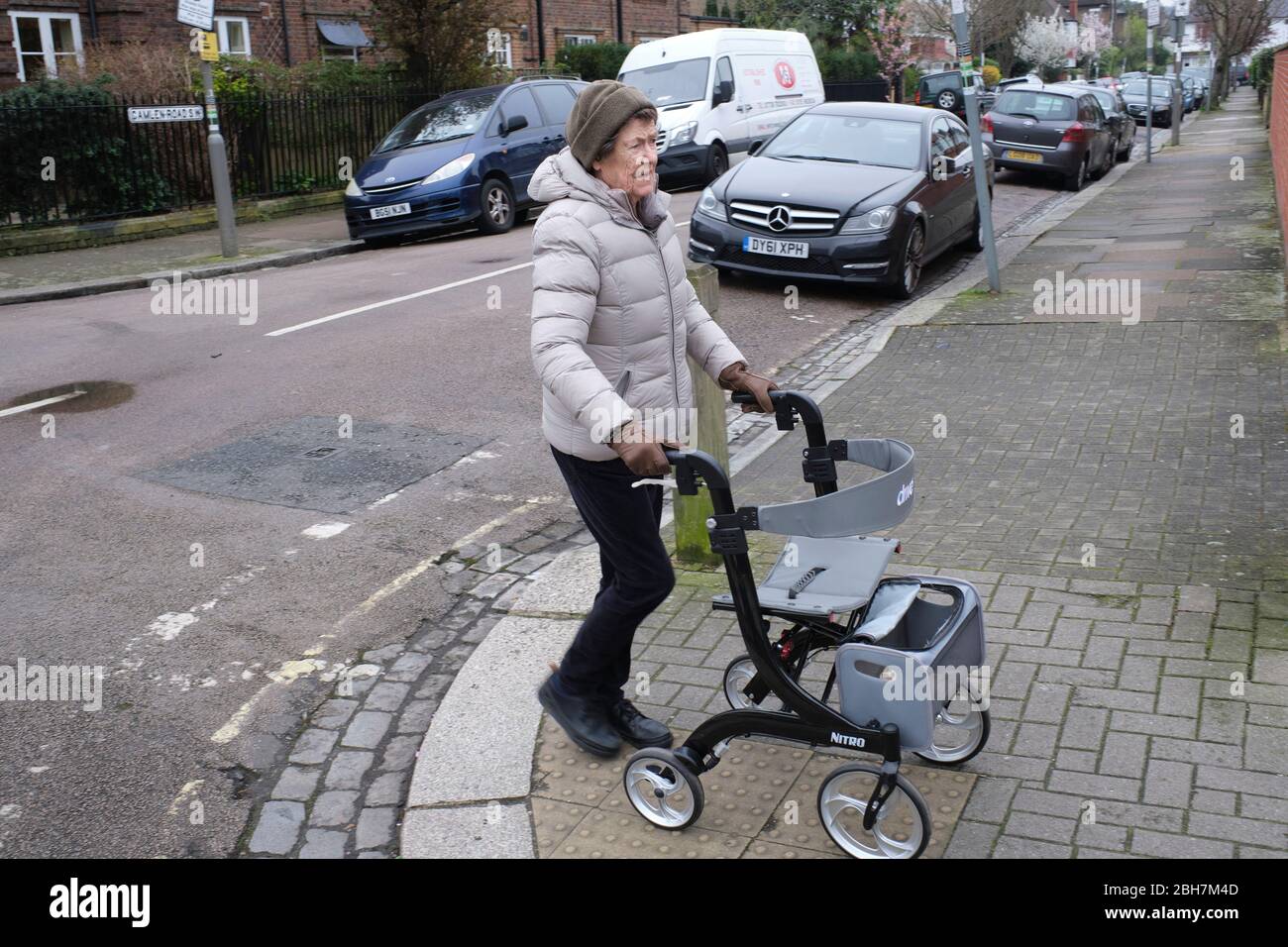 Social isolation. anyone aged 70 and over in the UK must self-isolate at home. coronavirus outbreak lockdown. Retired lady with walker Stock Photo