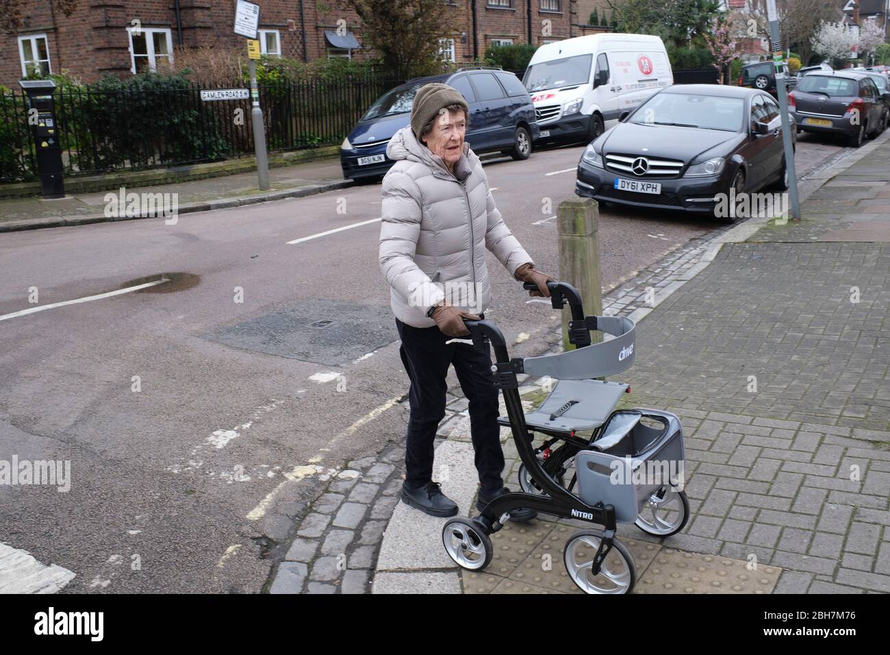 walkSocial isolation. anyone aged 70 and over in the UK must self-isolate at home. coronavirus outbreak lockdown. Retired lady with walking frame Stock Photo
