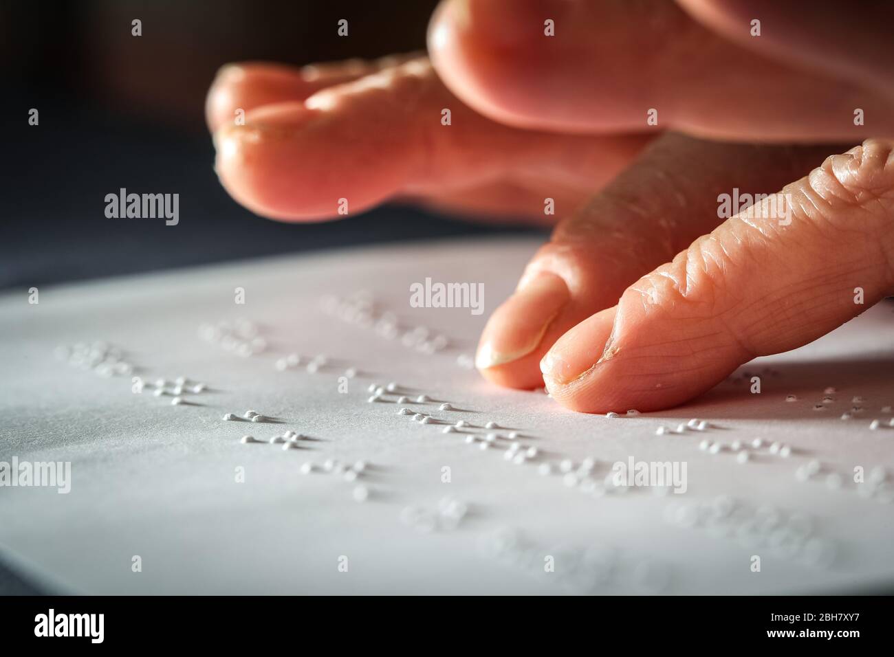 Close up photo of a woman hands reading braille text Stock Photo