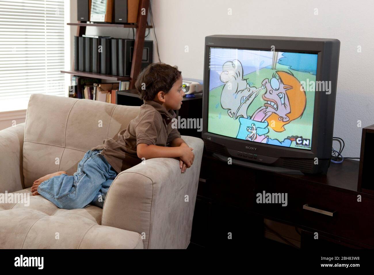 Austin, Texas USA, August 22, 2009: Five-year old Mexican-American boy watching Cartoon Network (CN) at home while relaxing on an overstuffed chair.  MR ©Bob Daemmrich Stock Photo