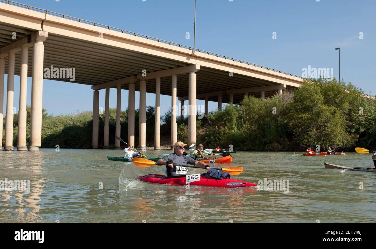 Laredo, Texas USA, October 17, 2009: Kayakers paddle a 33-mile stretch of the Rio Grande River between the Camino-Columbia International Bridge and downtown Laredo and Nueva Laredo in the first Dos Laredos RioFest. Over 100 racers from Texas and Mexico competed for prize money offered by local business in the first race of its kind on the Rio Grande. ©Bob Daemmrich Stock Photo