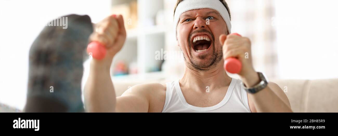 Guy doing exercises with dumbbells in his hands Stock Photo