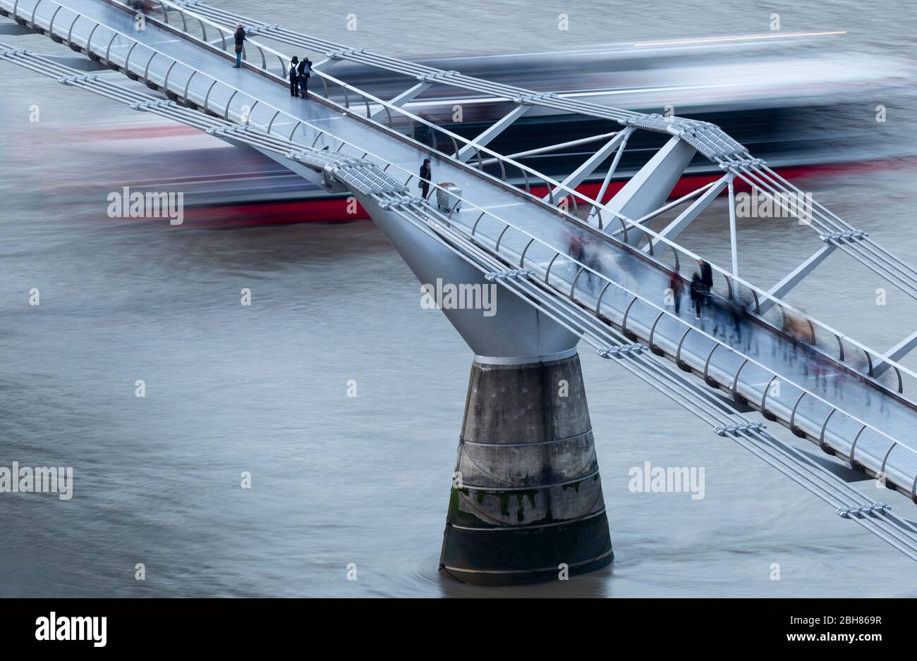 Long exposure of a boat passing under Millennium Bridge as seen from the viewing level of the Blavatnik Building, Tate Modern, London Stock Photo