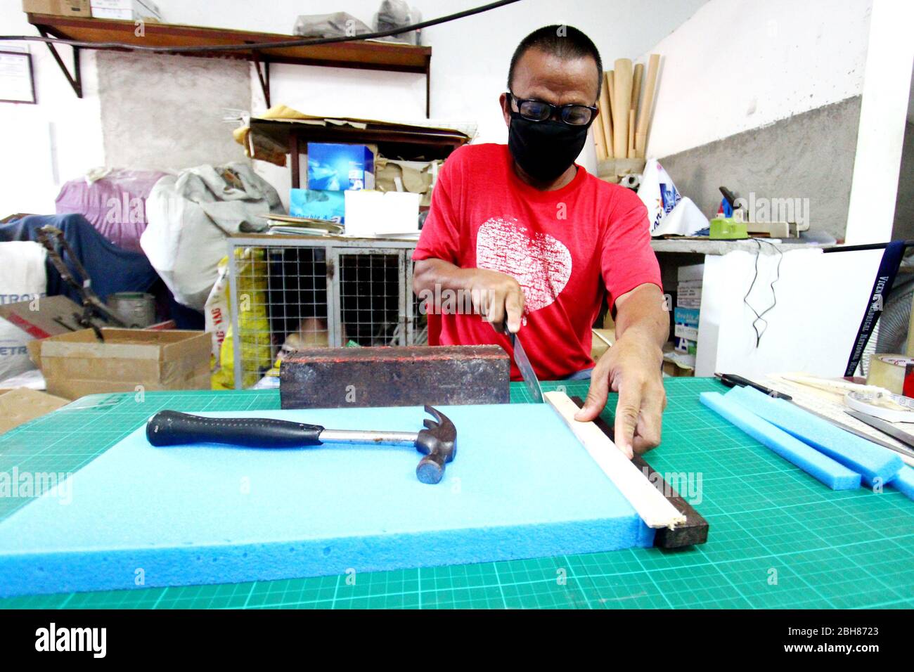 Philippines. 23rd Apr, 2020. Joseph Terenall while cutting the foam for face shield under supervision of Tina Nina Sta Ana in 18 Sitio Ilog Pugad, Brgy. San Juan, Taytay, Rizal. Sta. Ana twin sisters of Taytay province of Rizal on April 23, 2020. Tracy Z. Sta Ana and Tina Nina Z. Sta Ana produces PPE for the frontliners who fight for the Covid-19 pandemic that shock the humanity. (Photo by Gregorio B. Dantes Jr./Pacific Press/Sipa USA) Credit: Sipa USA/Alamy Live News Stock Photo